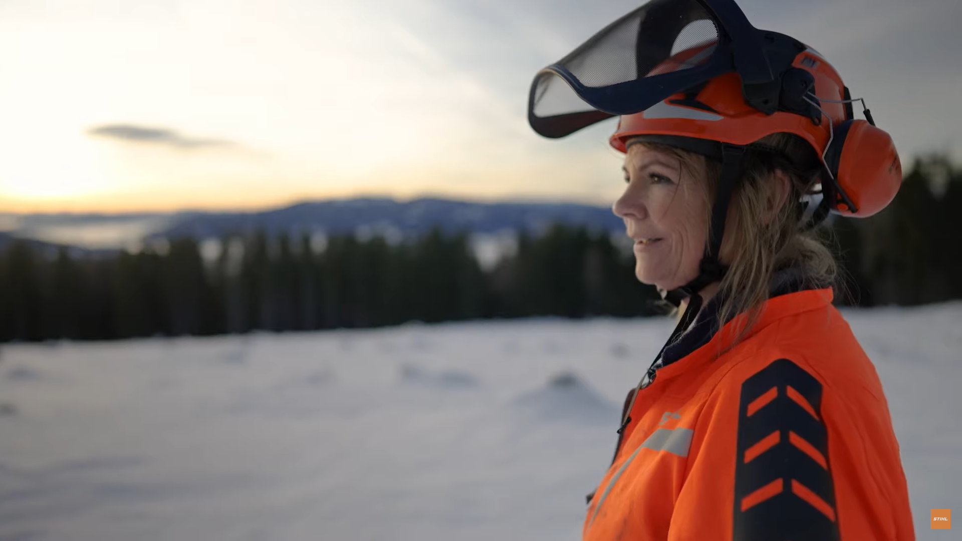 Professional woman with opened helmet in snowy landscape